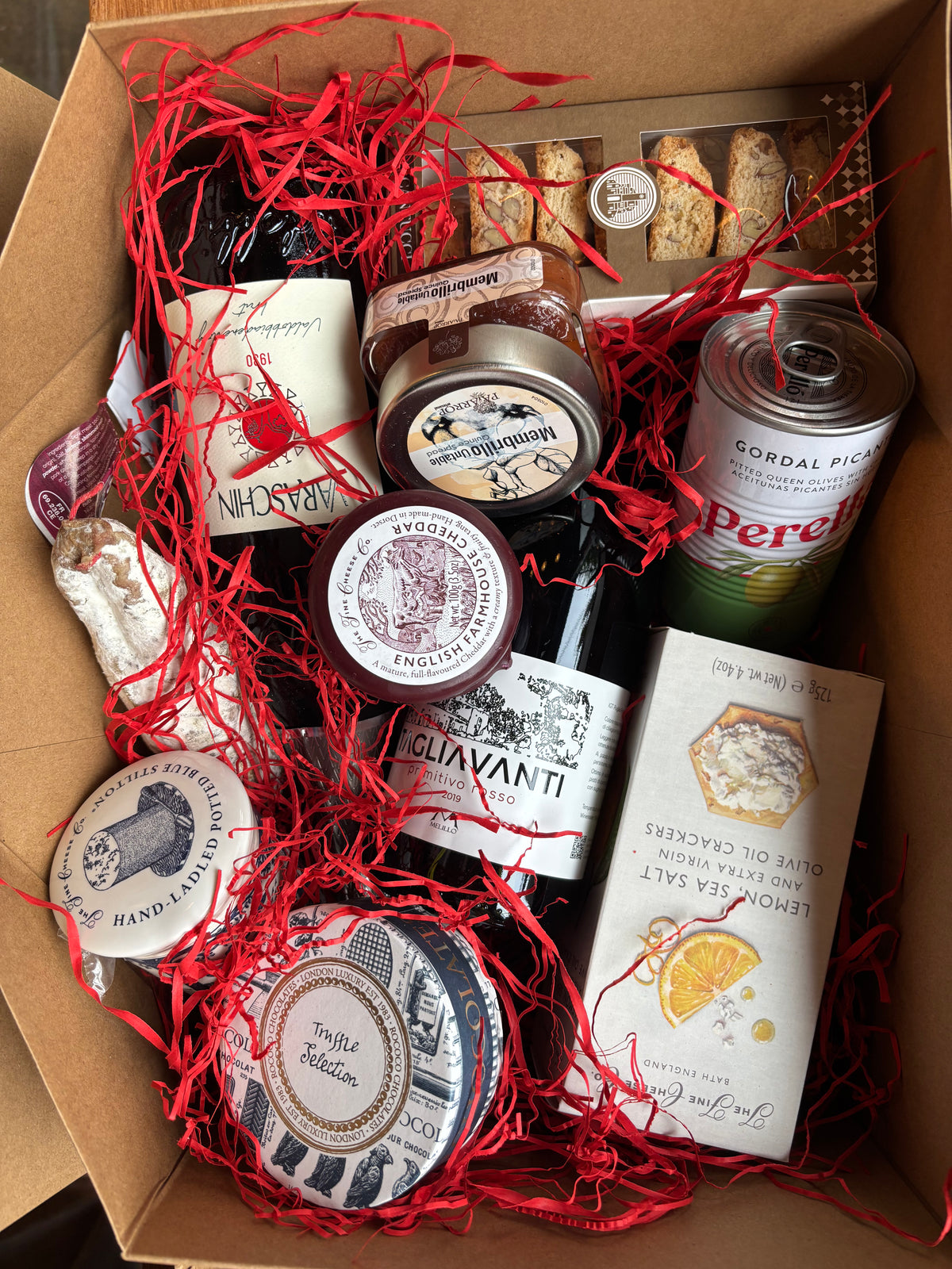 Gift box with assorted items including wine, cheese and confectionary.